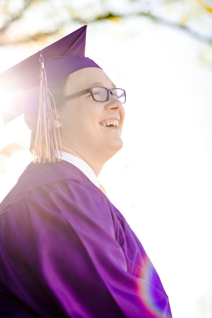 senior guy wearing purple cap and gown