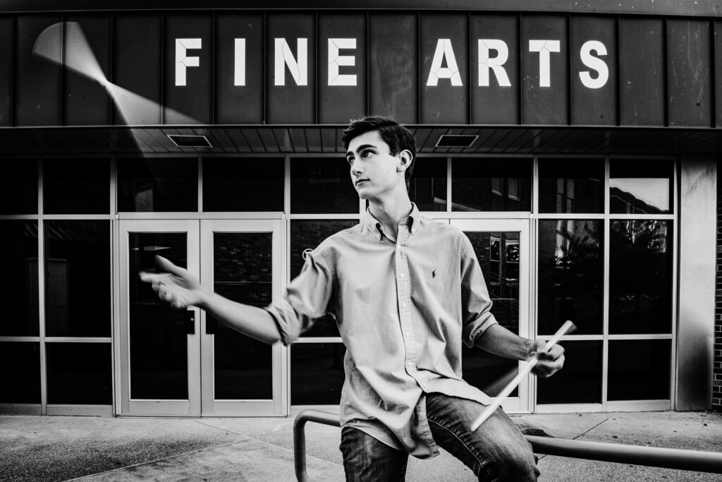 senior guy tossing drum sticks