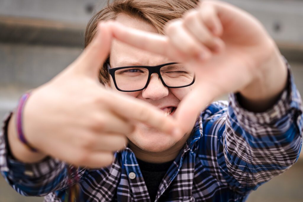 senior guy framing fingers to look at camera