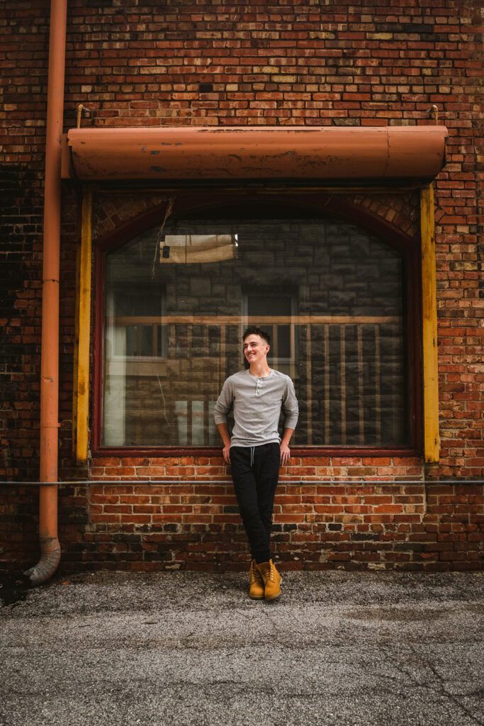 senior guy leaning on glass window