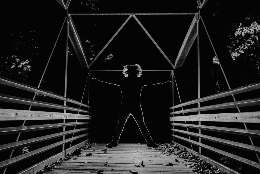 senior guy jumping on bridge