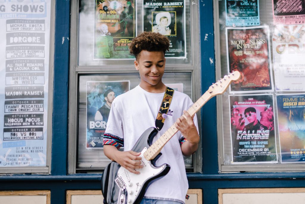 senior guy playing guitar outside blue note