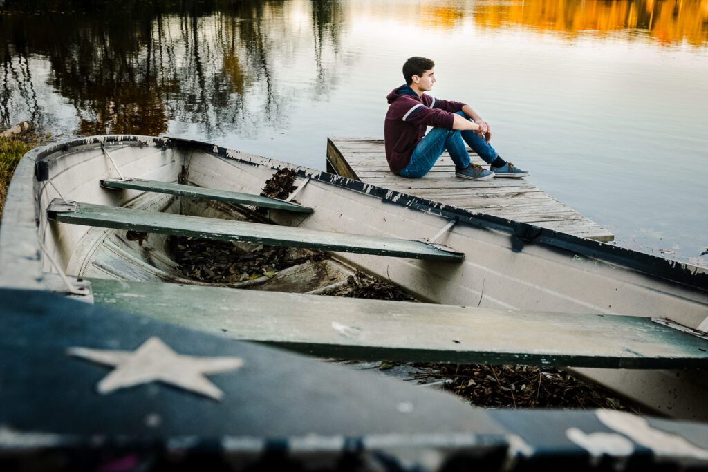 senior guy sits by lake