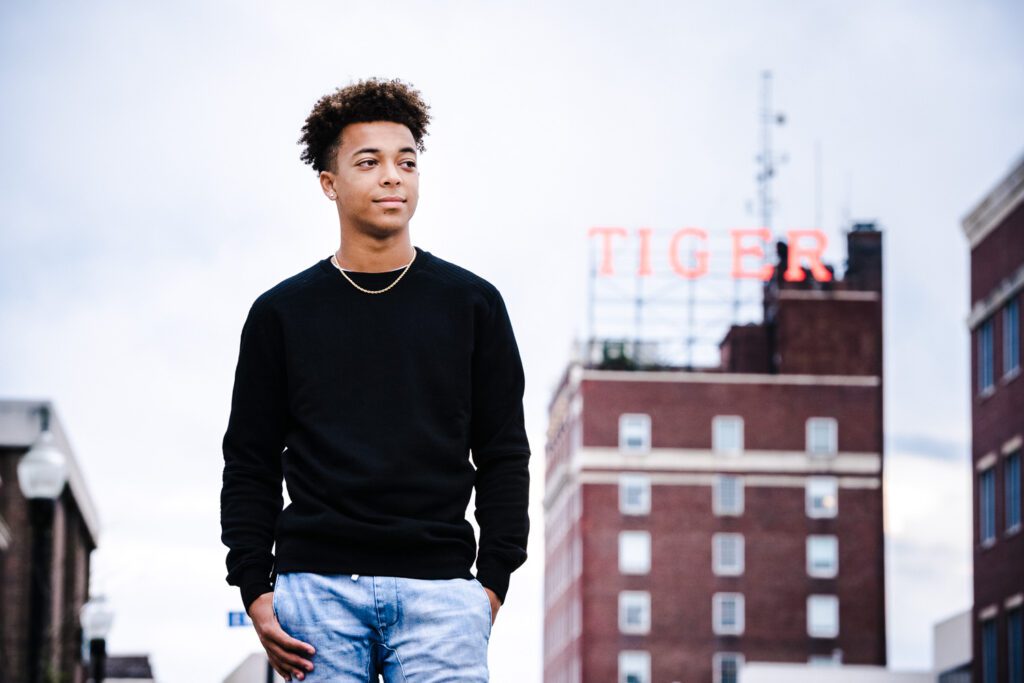 senior guy stands in front of tiger hotel sign