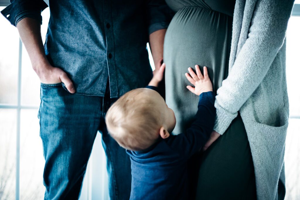 son holding mother's pregnant belly