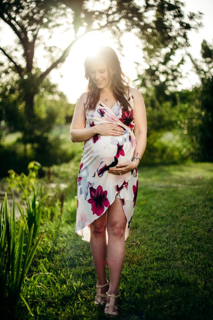 pregnant girl holding belly in forest