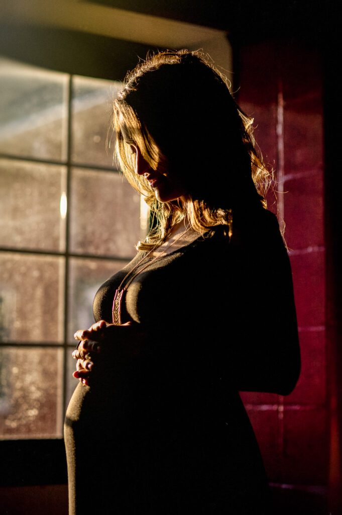 sun coming through window on pregnant woman holding stomach