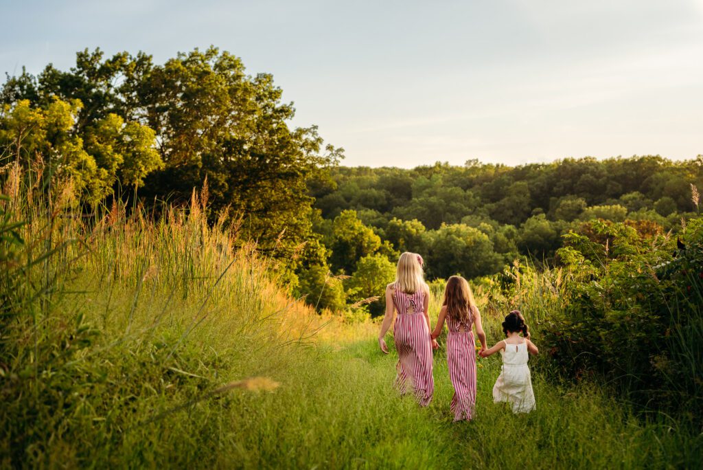 three sisters walking in a field at rock bridge state park