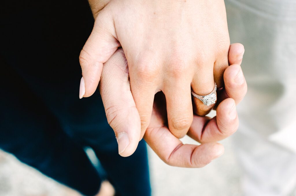 engagement ring on couple holding hands