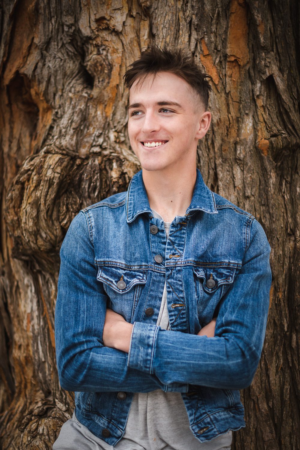 Battle High School Senior Will Doolady leans on a tree near Columbia College in Columbia Missouri by Scott Schaefer of Schaefer Photography.  