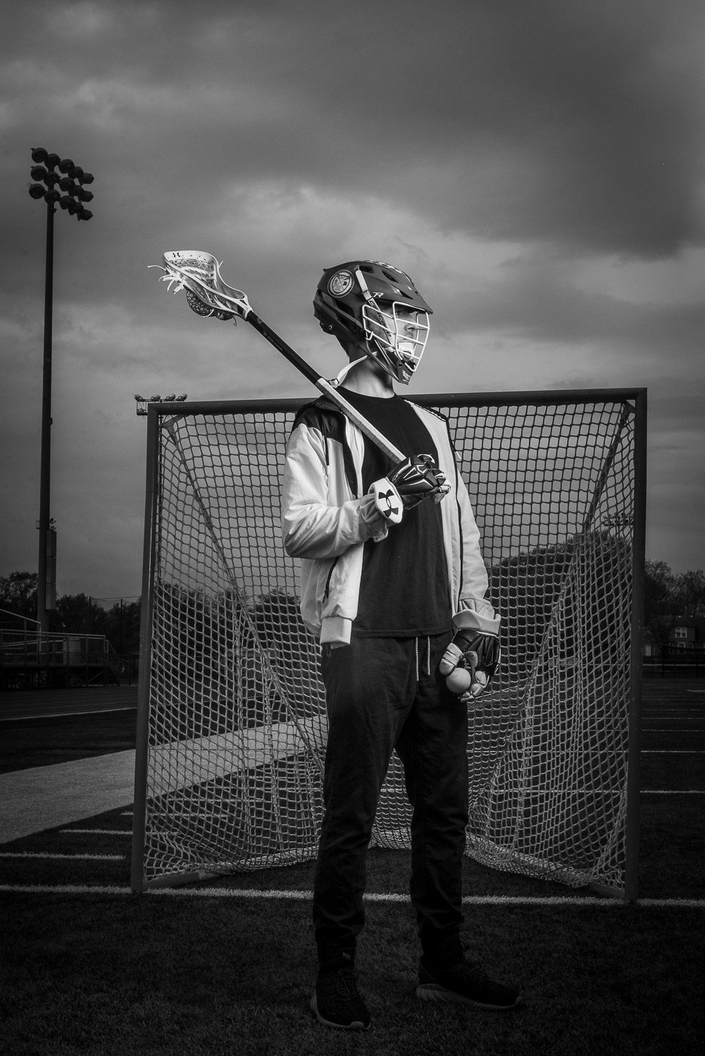 Battle High School Senior Will Doolady poses with his lacrosse helmet at Hickman High school in Columbia Missouri by Scott and Shannon Schaefer of Schaefer Photography.  