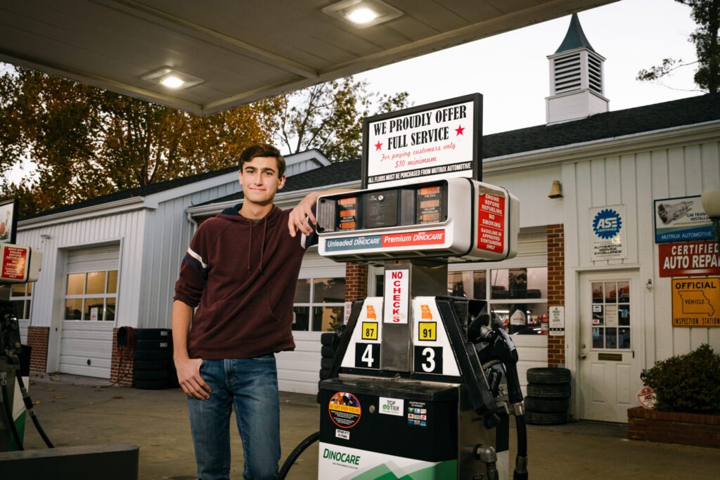 Hickman senior guy leaning on gas pump at Mutrux Automotive Columbia, MO