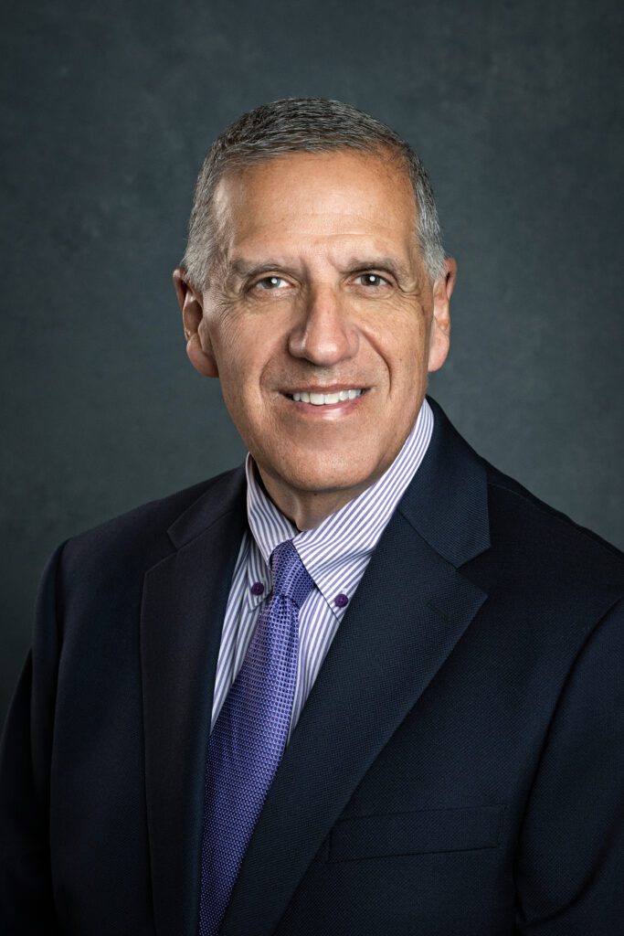 Professional headshot for doctor wearing purple tie and dark suit