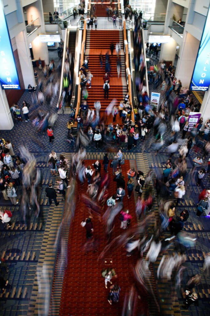 A large crowd moves through conference center