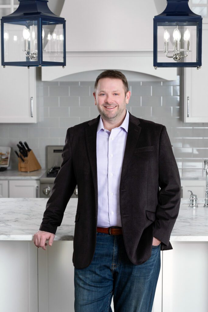 A realtor poses in a kitchen