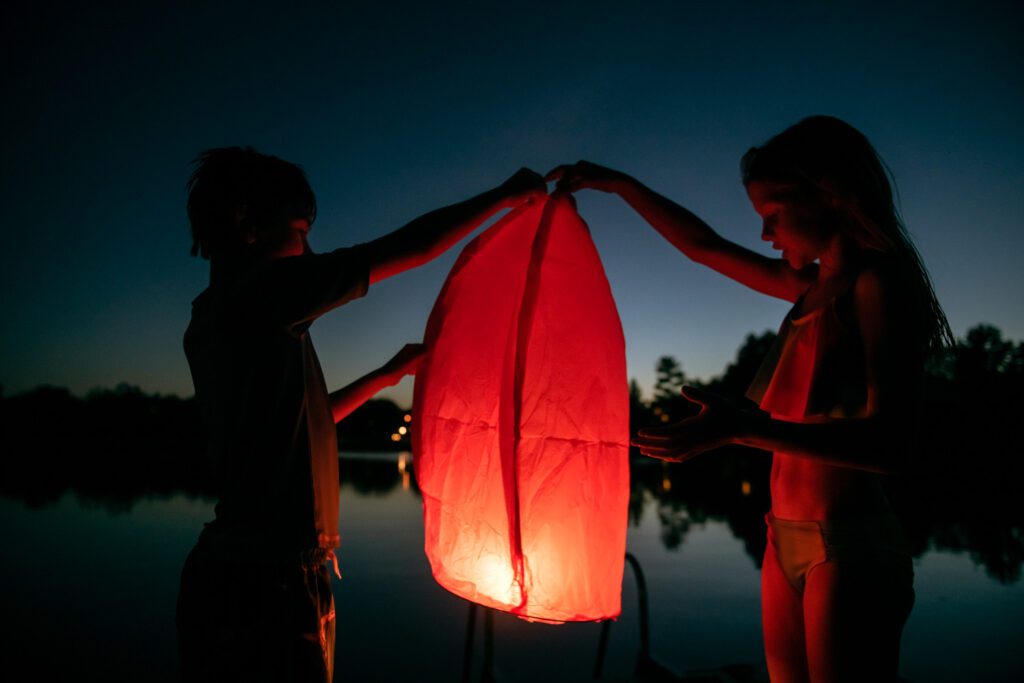 Children releasing a floating lantern with a flame