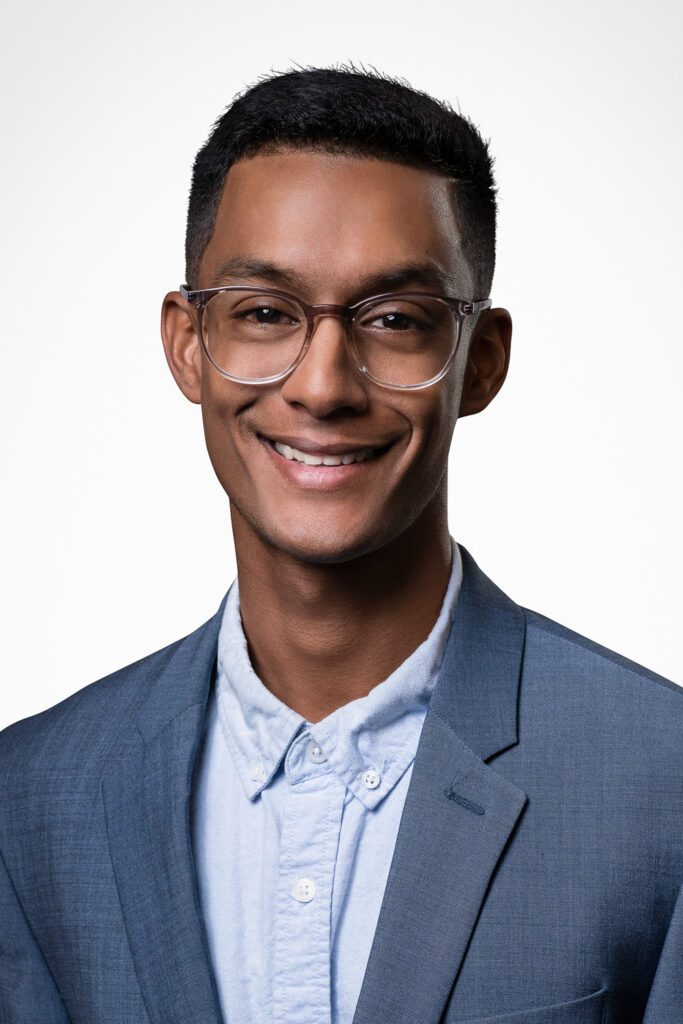 Young male professional headshot with light blue shirt.