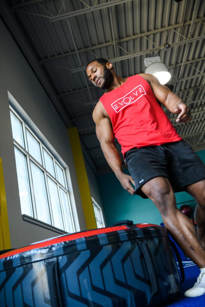 Male athlete stands over life fitness tire.
