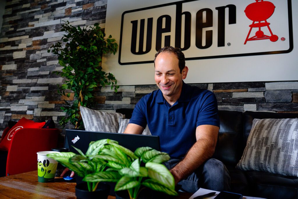 weber grill employee works on laptop