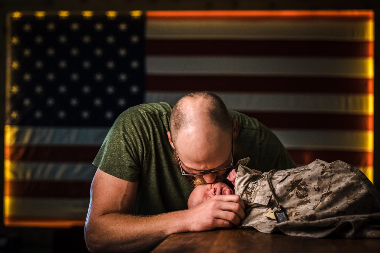 marine kissing newborn