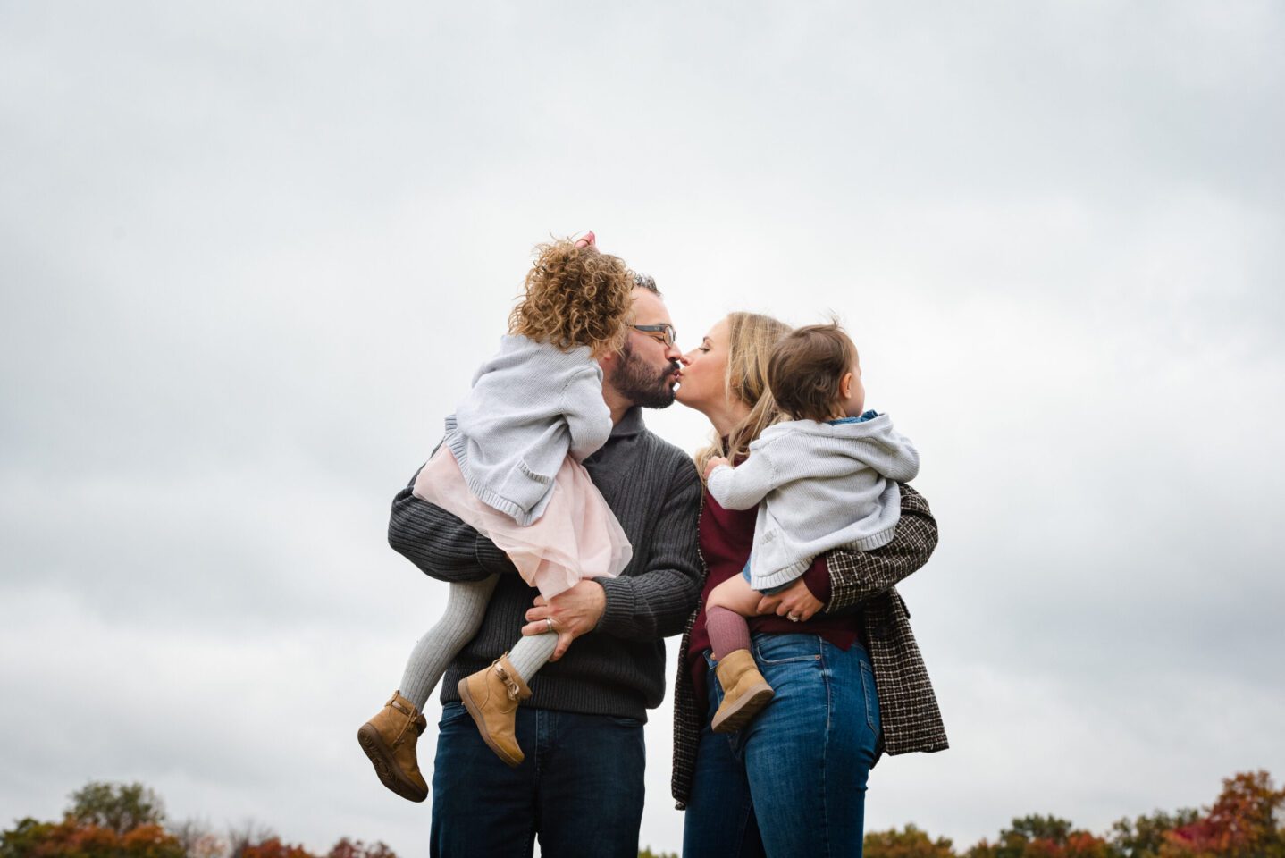 Parents kissing while holding children