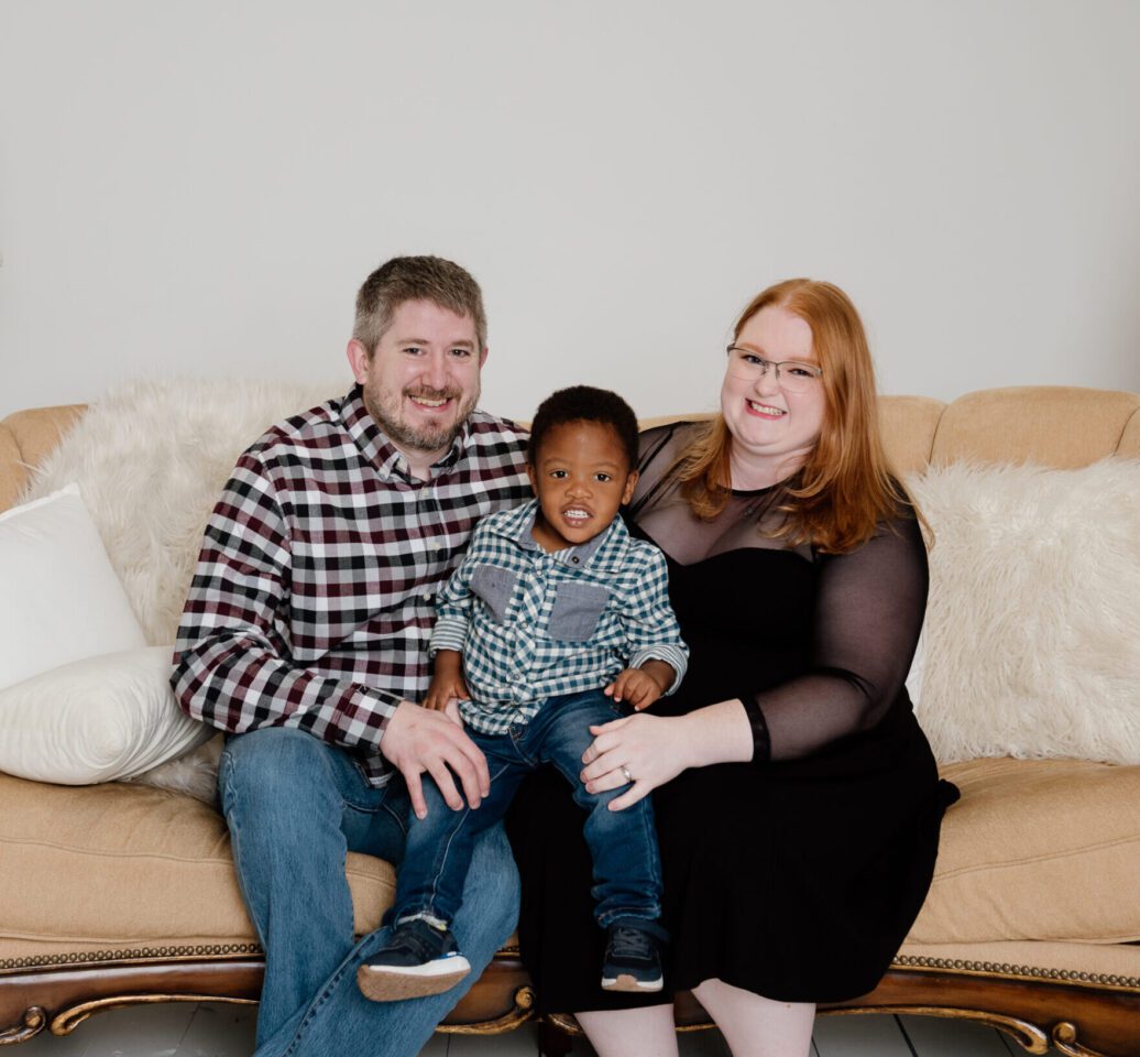 family sitting on yellow couch