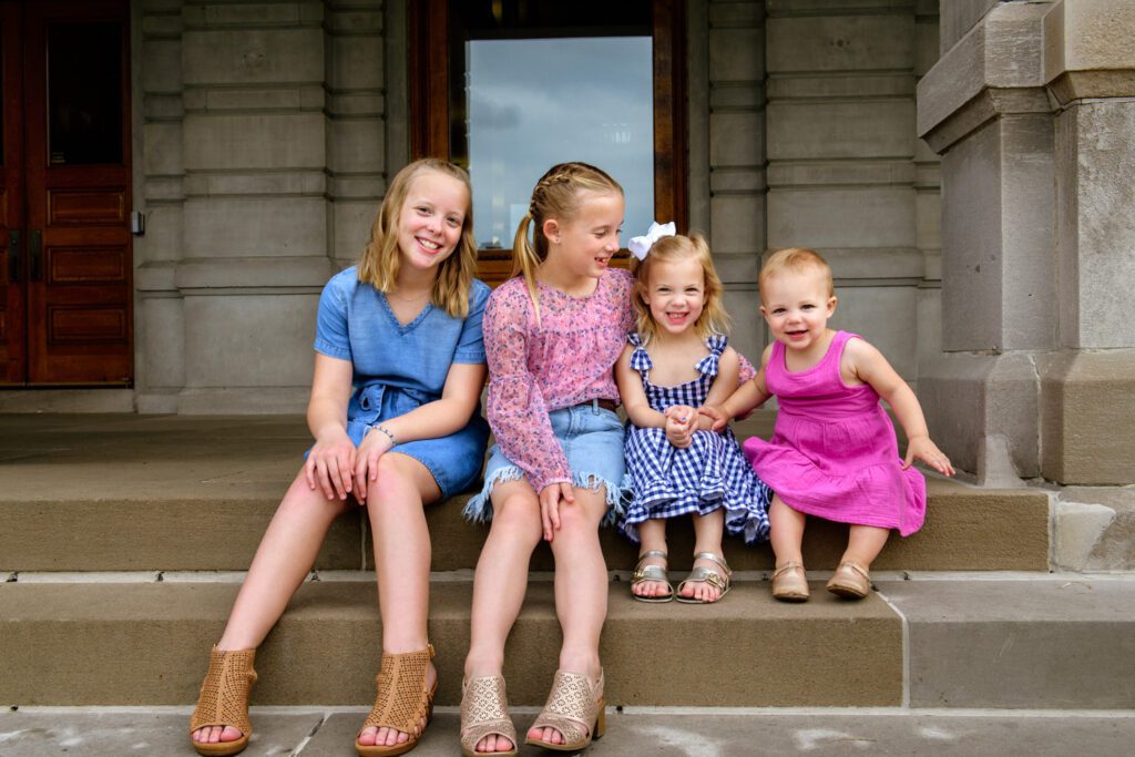 Four little kids sitting on step.