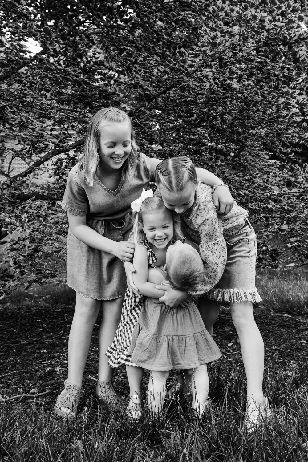 Sisters hugging smallest sister during Mizzou Campus Family Photos by Schaefer Photography.