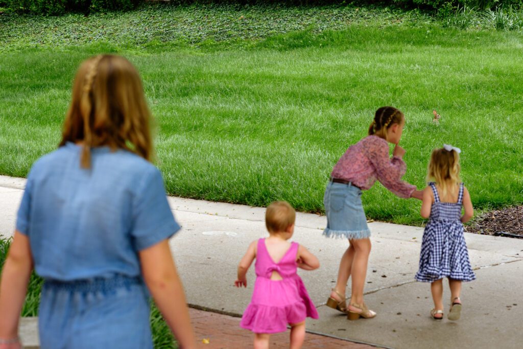 Children try to sneak up on a bunny rabbit.