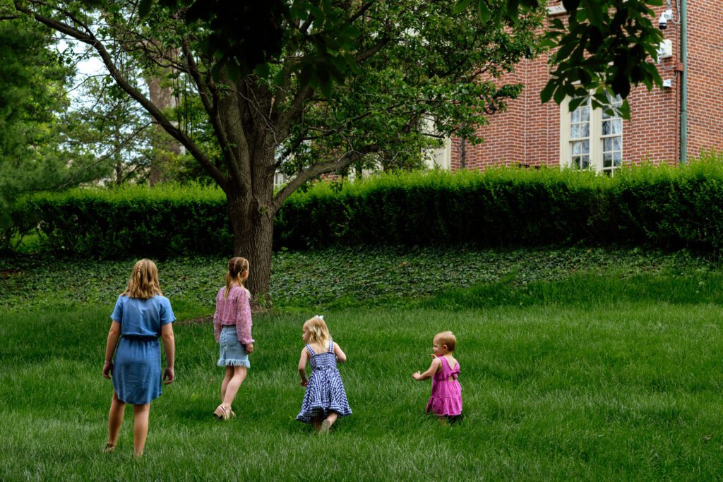 A wide shot of four sisters walking in the grass.