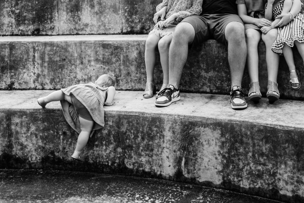 Small child tries to climb a large concrete step.