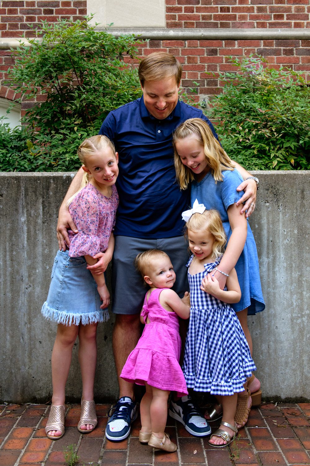 Father hugs his four daughters.