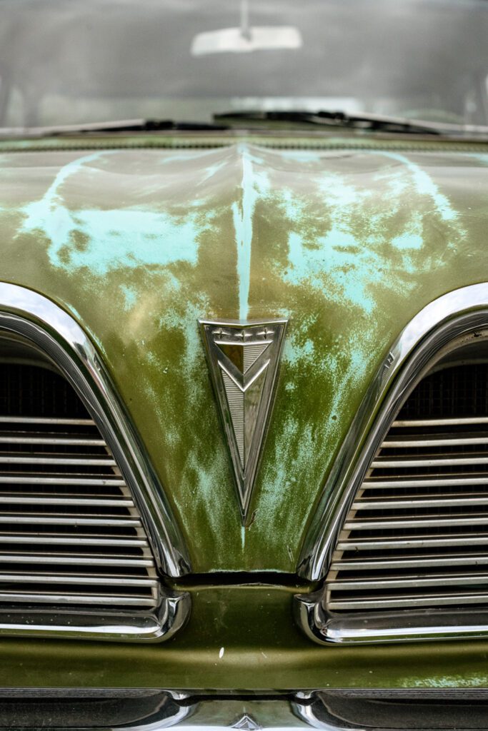 Close up shot of green and turquoise Pontiac Catalina hood ornament.
