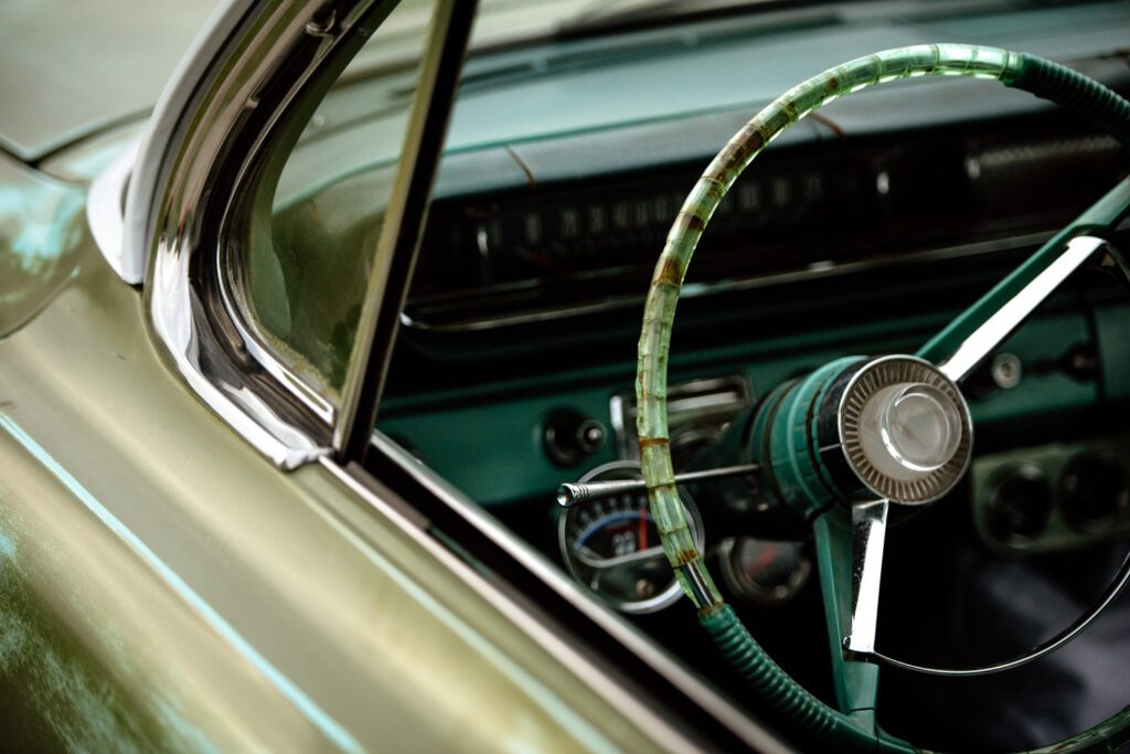 Steering wheel and mirror of green pontiac catalina.