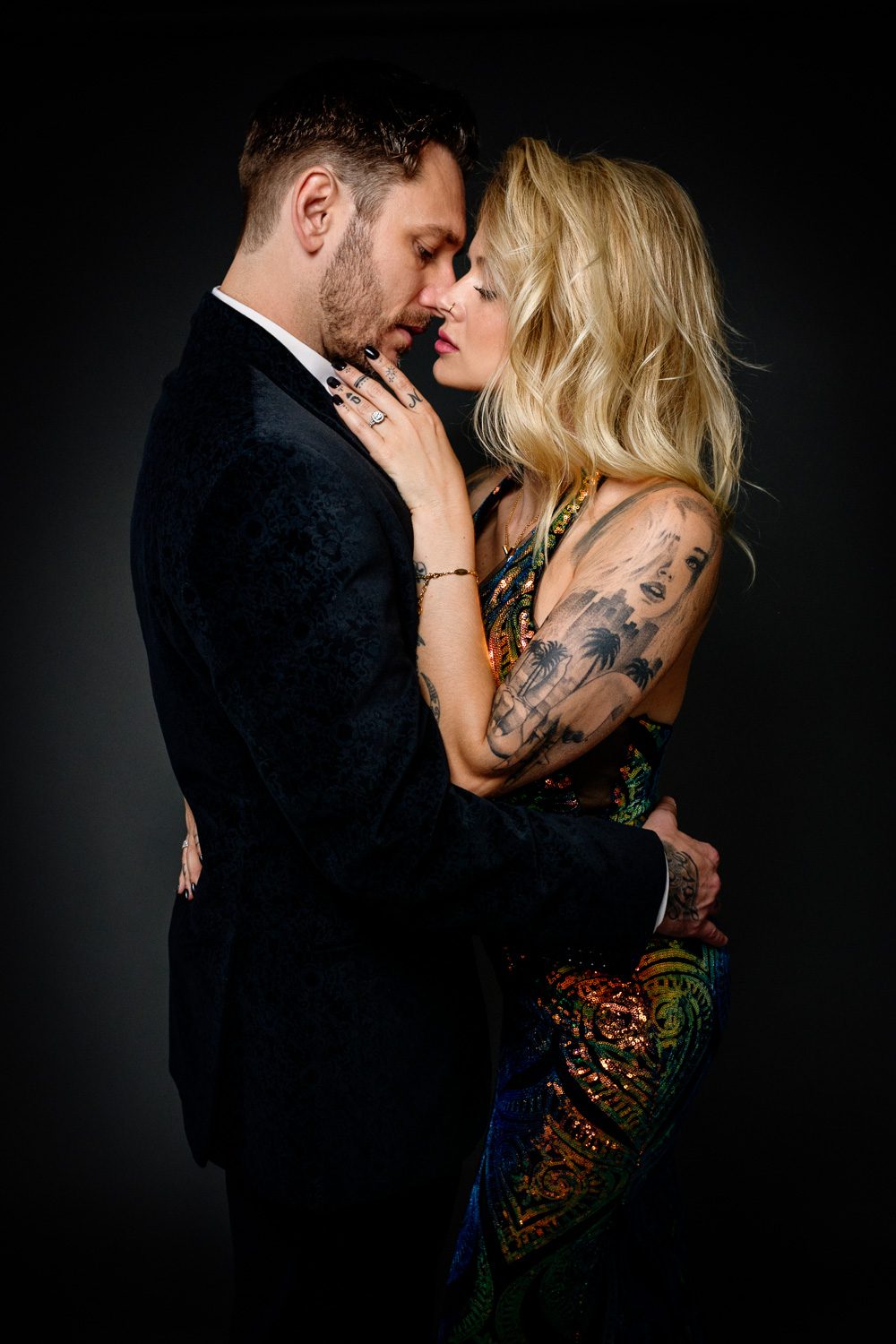 romantic couple wearing evening gown and suit photographed just before they kiss.