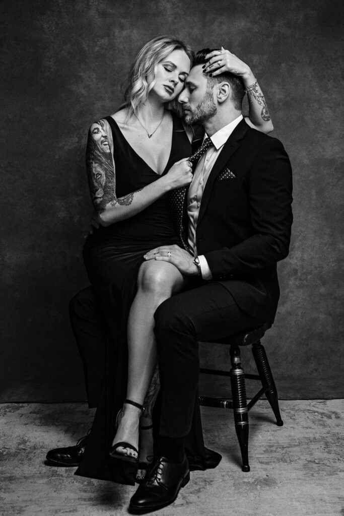 romantic couple embrace while sitting on a chair