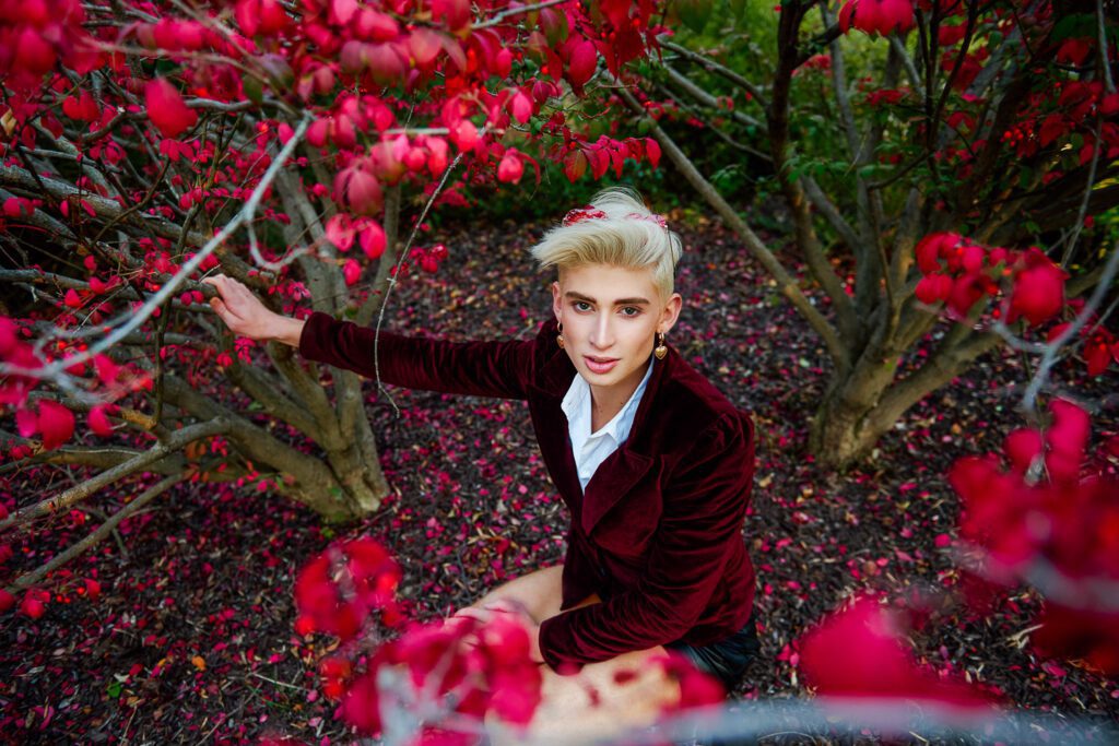 Zachary Willmore wearing red jacket by burning bush.
