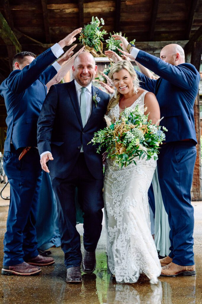 Bride and Groom walk through tunnel made by wedding party at dogwood canyon