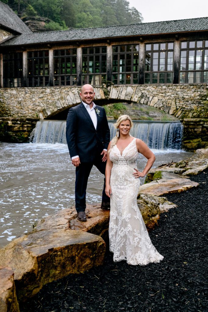 Bride and Groom Stand on rocks Dogwood Canyon