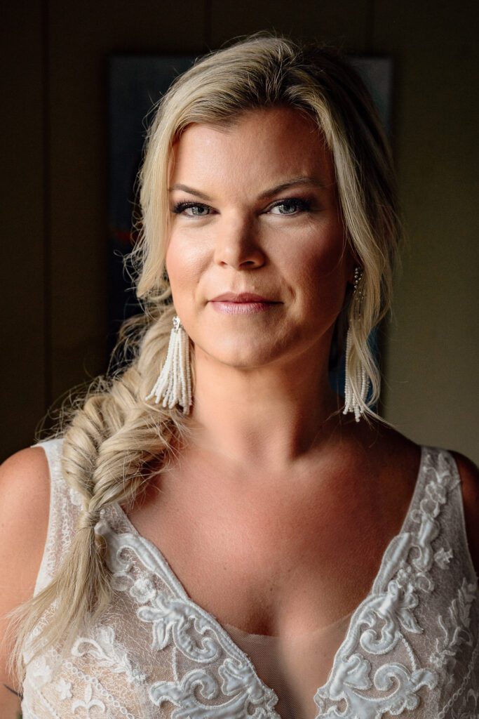 Portrait of blonde bride wearing wedding dress looking at camera.