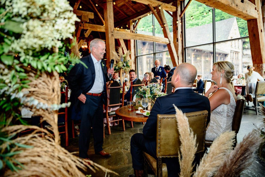 Father of the bride tells a joke as bride and groom watch