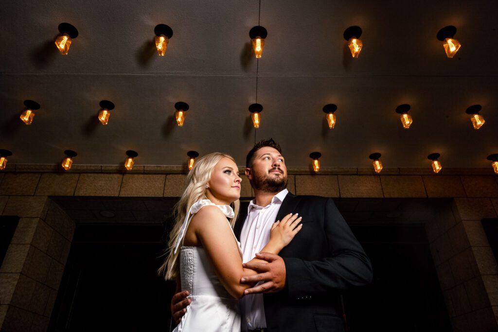 Couple cuddle together under light bulbs tiger hotel columbia missouri by schaefer photography
