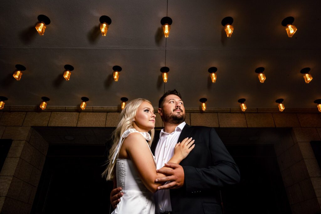 Couple cuddle together under light bulbs tiger hotel columbia missouri by schaefer photography
