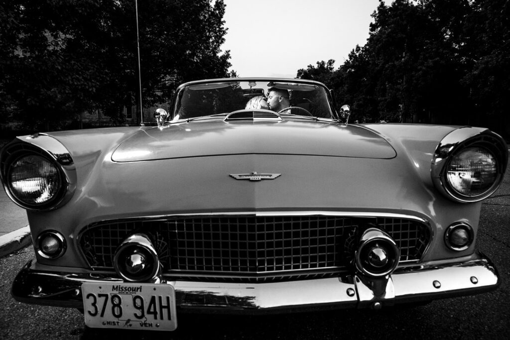 Couple kiss while sitting in 1956 Thunderbird