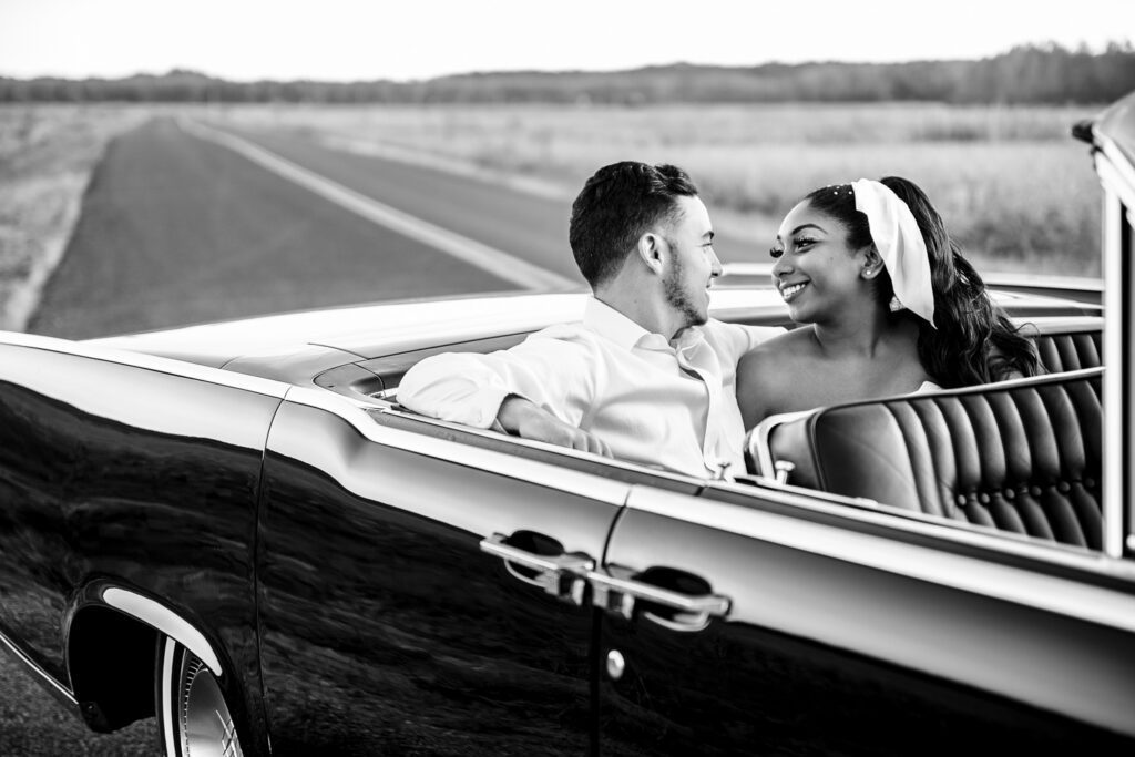 Engaged Black Couple sit in the back seat of a 1966 Lincoln Continental Convertible.