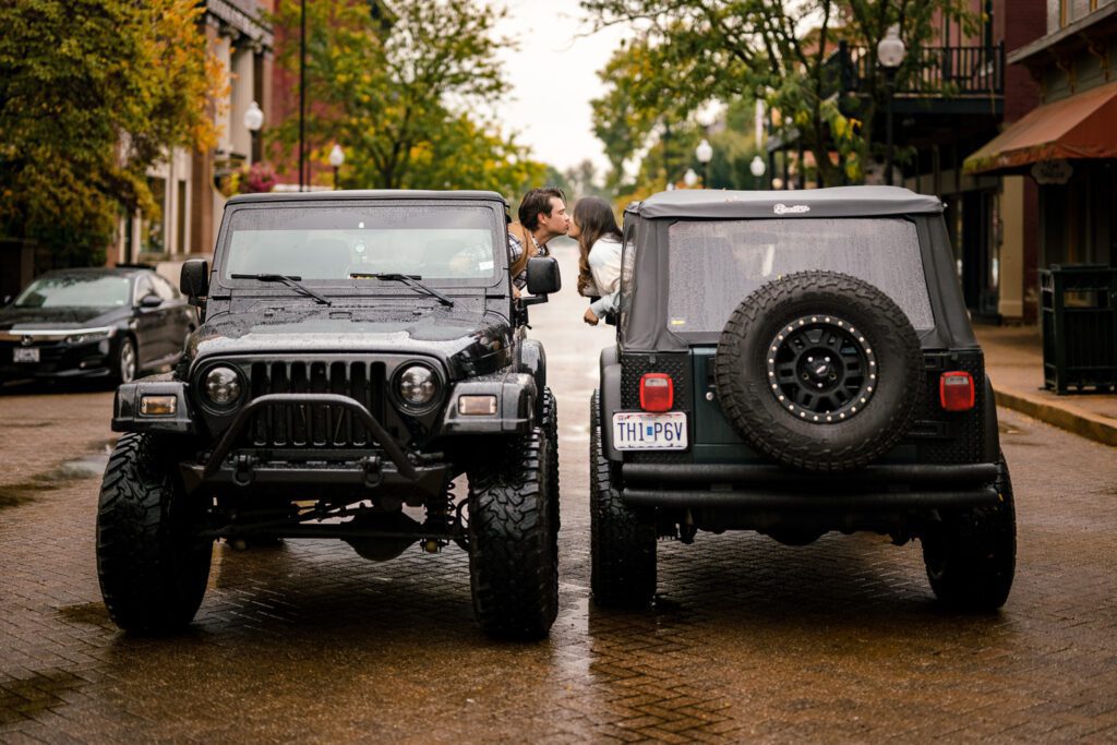 A couple kiss while parked on St. Charles street in identical black jeeps.