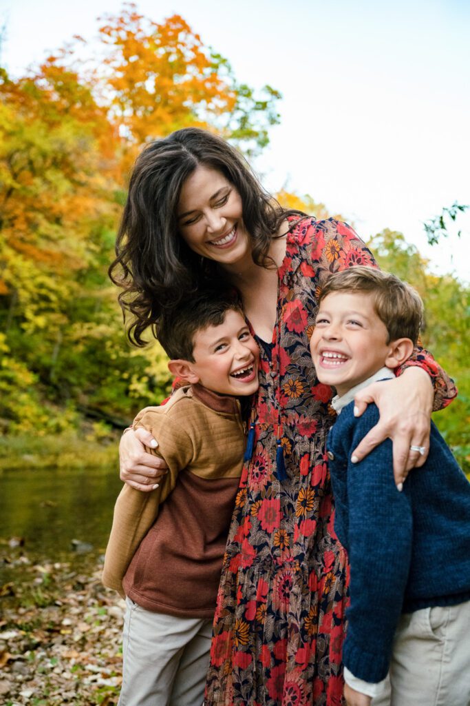 Two young boys and their mother laugh while hugging in Capen Park in Columbia, Missouri.