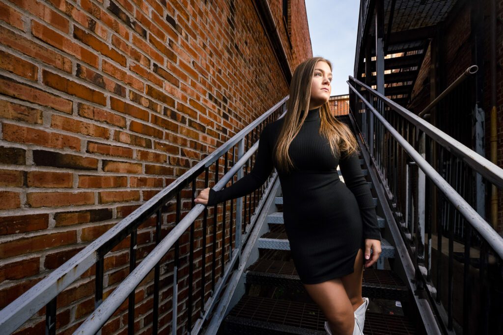 Senior girl stands in alleyway staircase