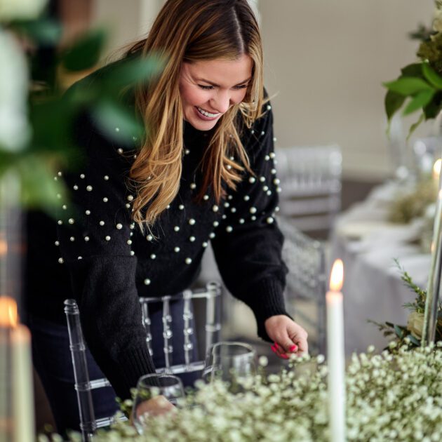 Ashley Gross Minor from Delight Events arranges a place setting for a wedding.