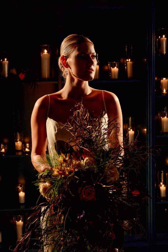 bride with slicked back bun on front of candle wall